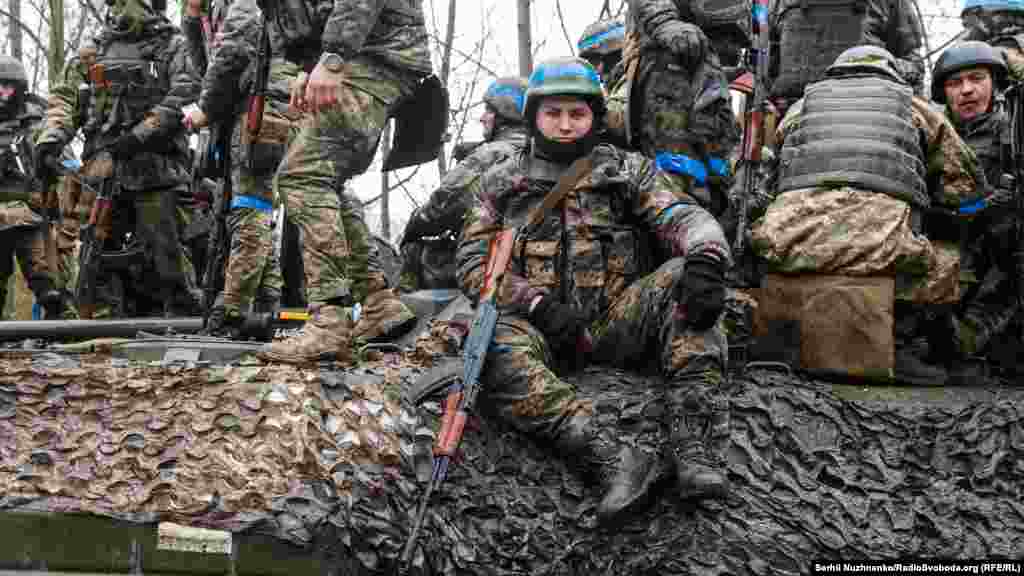 Бійці вантажаться на бронетехніку – БМП та танк – у повній бойовій готовності