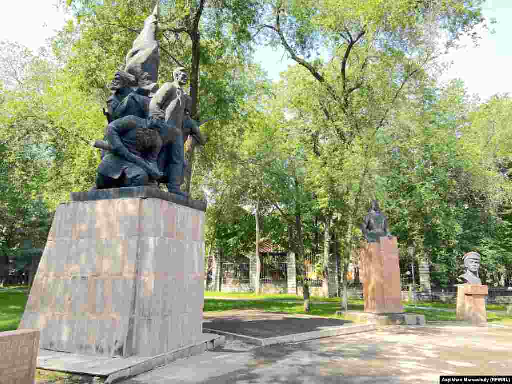 Сол жақ шетте 1917 жылғы Қазан төңкерісіне қатысушыларға арналған ескерткіш тұр. Оның тұғырына "Өшпес ерліктерің разы ұрпақ жүрегінде мәңгі жасайды. Октябрь, 1967 жыл" деп жазылған. Алматыдағы "Сарыарқа" кинотеатрының сыртындағы алаң. 28 мамыр, 2023 жыл.