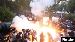 Armenia -Riot police fire stun grenades at antigovernment protesters outside the parliament building in Yerevan, June 12, 2024.