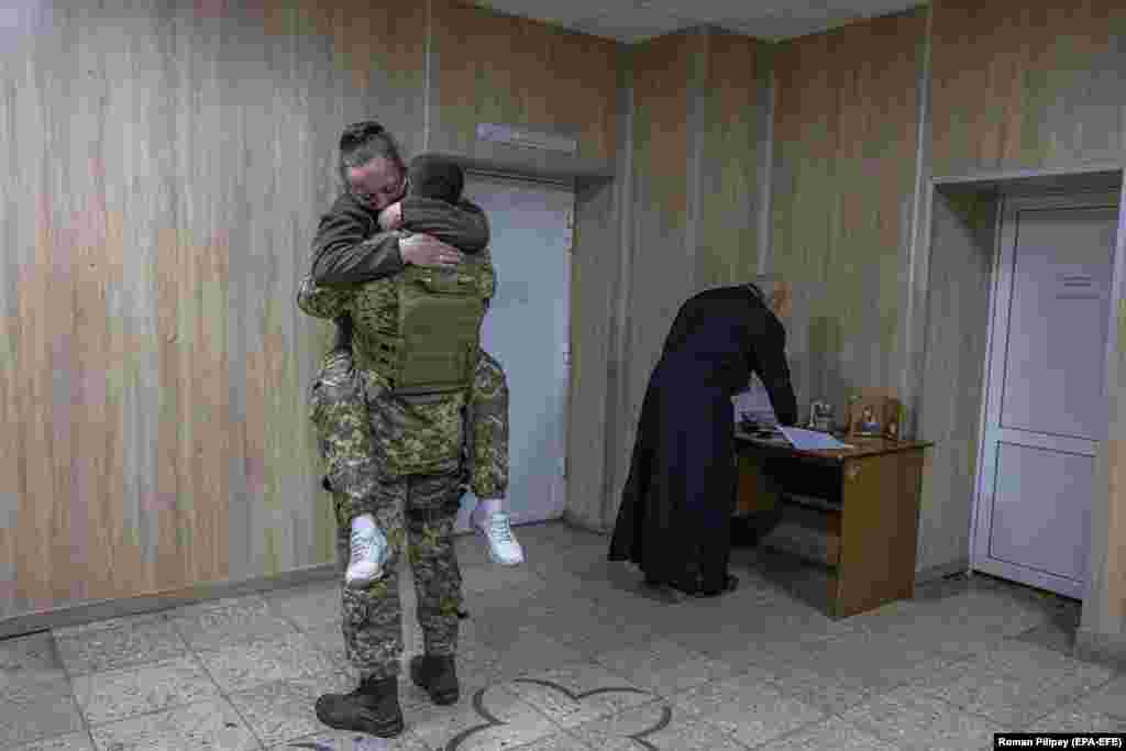 Подружжя українських військових обіймається після обміну шлюбними обітницями у Броварському районі Київської області на тлі наступу російської армії на Київ. Молодята, які побажали залишитися анонімними, вперше зустрілися на сході України у 2015 році, коли разом воювали проти підтримуваних Росією угруповань «ЛДНР». Їхні стосунки почалися тоді, коли вони випадково зустрілися вже під час повномасштабного вторгнення Росії в Україну у 2022 році.