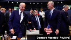 U.S. President Joe Biden (left) prepares to sit as he speaks with NATO Secretary-General Jens Stoltenberg at the alliance's headquarters in Brussels on March 24.