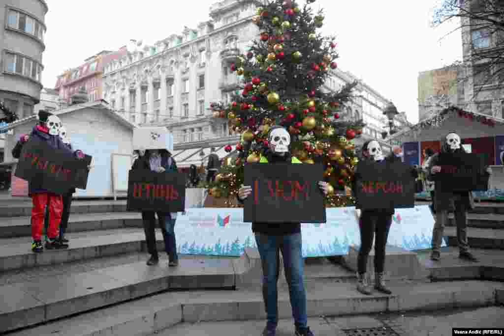 Aktivisti neformalnog udruženja &quot;Rusi, Ukrajinci, Belorusi i Srbi zajedno protiv rata&quot; sa maskama i transparentima razorenih gradova u Ukrajini ispred ruske novogodišnje jelke u centru Beograda. &quot;Na ovaj način podsećamo na zločine i razaranje koje vrši ruska vojska&quot;, poručili su aktivisti.