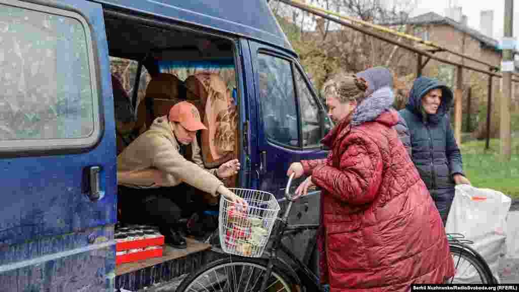 Волонтер Тетяна роздає продукти місцевим жителям на одній з вулиць Мар‘їнки. 14 квітня 2022 року. За словами волонтерів у місті залишилось ще багато місцевих жителів, які з різних причин не евакуйовуються із зони бойових дій 