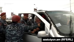 Полицейские на улице Афин задерживают участников автошествия, Ереван, 16 мая 2022 г. 