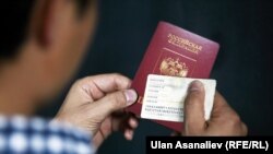 Колуна кыргыз жана орус паспортун кармап турган мигрант жигит