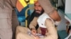 د رېسکیو ۱۱۲۲ یو روغتیايي کارکوونکی په امبولانس کې د ژوبل کس لومړنۍ طبي مرسته کوي - د جولای ۲۷مې انځور. 