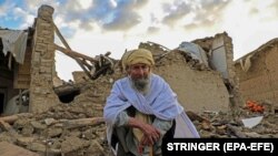 په ګیان ولسوالۍ کې یو کس د ړنګ کور په کنډواله کې ناست دی - د جون ۲۳مې انځور. 