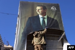 Militant skidaju portret sirijskog predsednika Bašara el Asada u Alepu 30. novembra, nakon što su džihadisti i njihovi saveznici ušli u taj grad na severu Sirije.