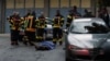 Vatrogasci stoje uz telo na mestu pucnjave u kojoj je život izgubilo 11 osoba u Cetinju u Crnoj Gori 12. avgusta 2022. 