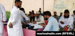 د انتخاباتي کمېشن چارواکي په ووټر لېسټونو کې د رایې اچوونکو نومونه ګوري - د جولای ۱۷مې انځور.