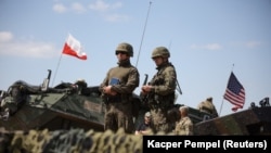 POLAND - Polish and American soldiers stand during Defender Europe 2022 military exercise of NATO troops at the military range in Bemowo Piskie, May 24, 2022.