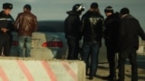 На блокпосту у въезда в Жанаозен полицейские сверяют лица и документы проверяемых с фотографиями и данными разыскиваемых по подозрению в участии в беспорядках в Жанаозене. 26 декабря 2011 года.