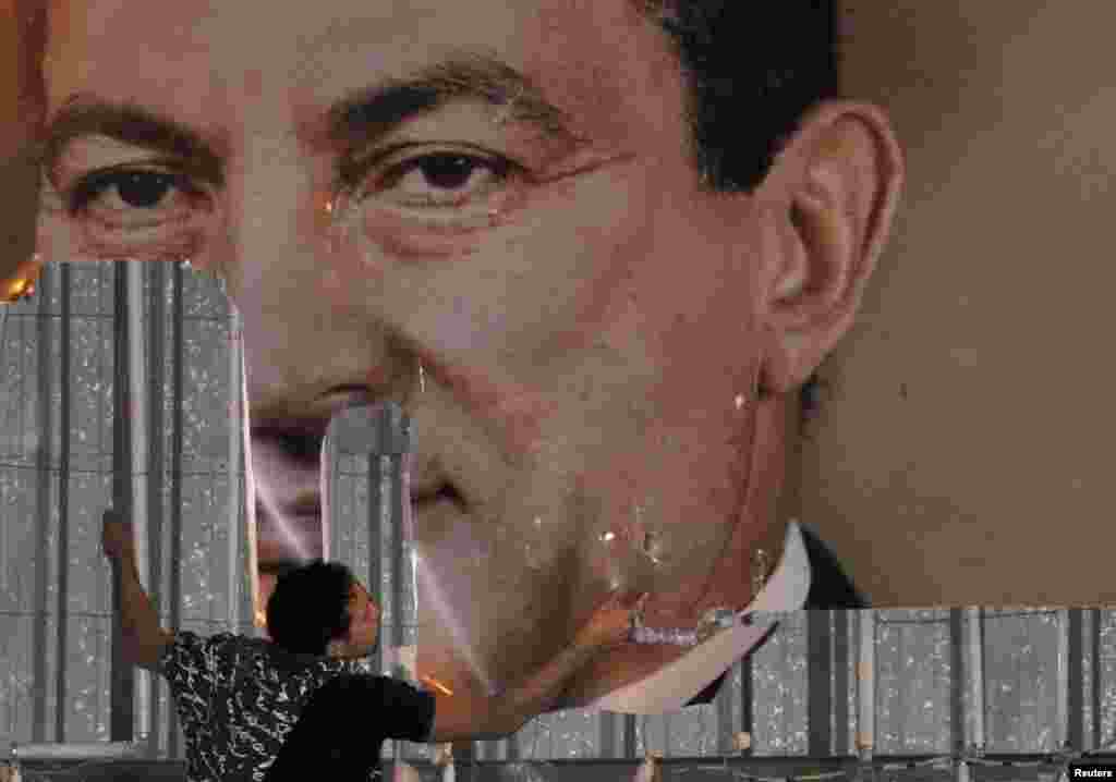 25 yanvar 2011. İsgəndəriyyə şəhərində aksiya iştirakçıları prezident Hosni Mubarak'ın portretini cırırlar.