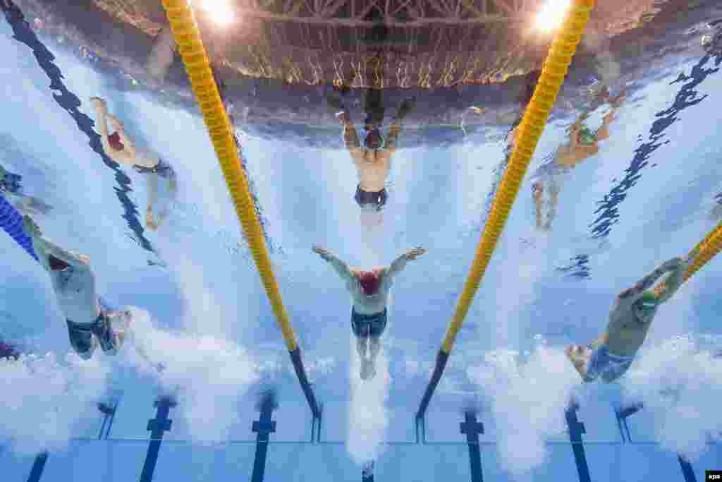 Great Britain's Adam Peaty (center) set a new world record in the men's 100-meter breaststroke heats.
