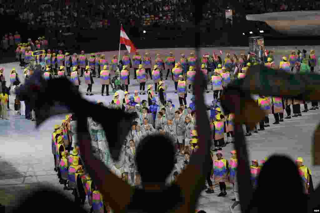 Spectators cheer the arrival of more than 10,000 athletes from 207 teams.