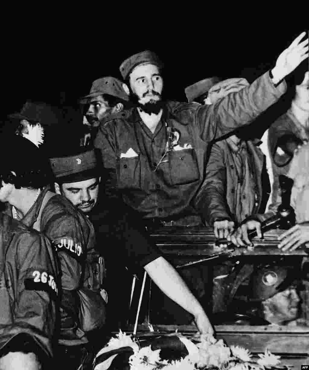 Okružen pripadnicima njegovog lijevog gerilskog krila, Castro (u sredini) maše masi u Cienfuegosu nakon svrgavanja s vlasti kubanskog diktatora Fulgencia Batiste, 1959. 