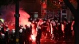 A flare burns as Serbian Riot Police move towards protesters as tens of thousands gather in central Belgrade to issue an "ultimatum" to the populist government to call early elections after months of student-led strikes across the country, in Belgrade, on