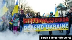 Демонстранти маршираат од споменикот на Линколн до Белата куќа за време на митингот „Застани со Украина“ во Вашингтон, САД, 20 февруари 2022 година