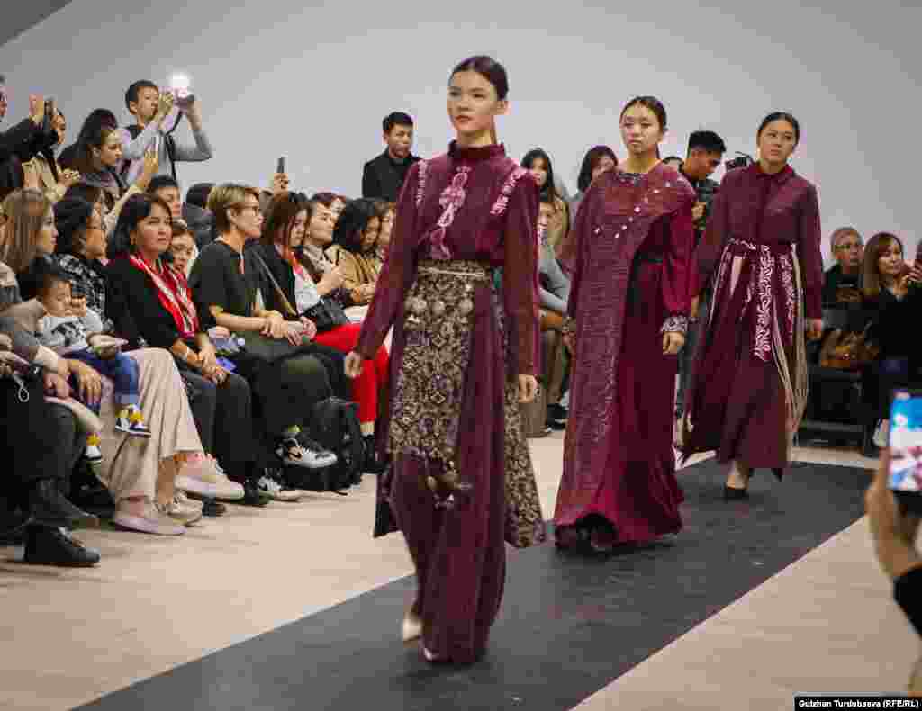 Замиру Молдошеву знают по известному бренду Z-Fashion. Новая ее коллекция отличается одеждой с широкими рукавами и юбками. Дополняет некоторые образы белдемчи - распашная юбка на широком поясе, надеваемая поверх платья или халата.