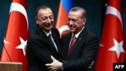 Turkey -- Azerbaijani President Ilham Aliyev (L) and Turkish President Recep Tayyip Erdogan hug after signing bilateral agreements following the 5th Turkey-Azerbaijan High Level Strategic Cooperation Council meeting at the Presidential Complex in Ankara,