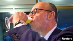 Германският консервативен кандидат за канцлер и лидер на Християндемократическия съюз (ХДС) Фридрих Мерц пие бира след обявяването на резултатите от екзитпола за общите избори през 2025 г. Партията му стана първа политическа сила при най-високата избирателна активност от 35 г.