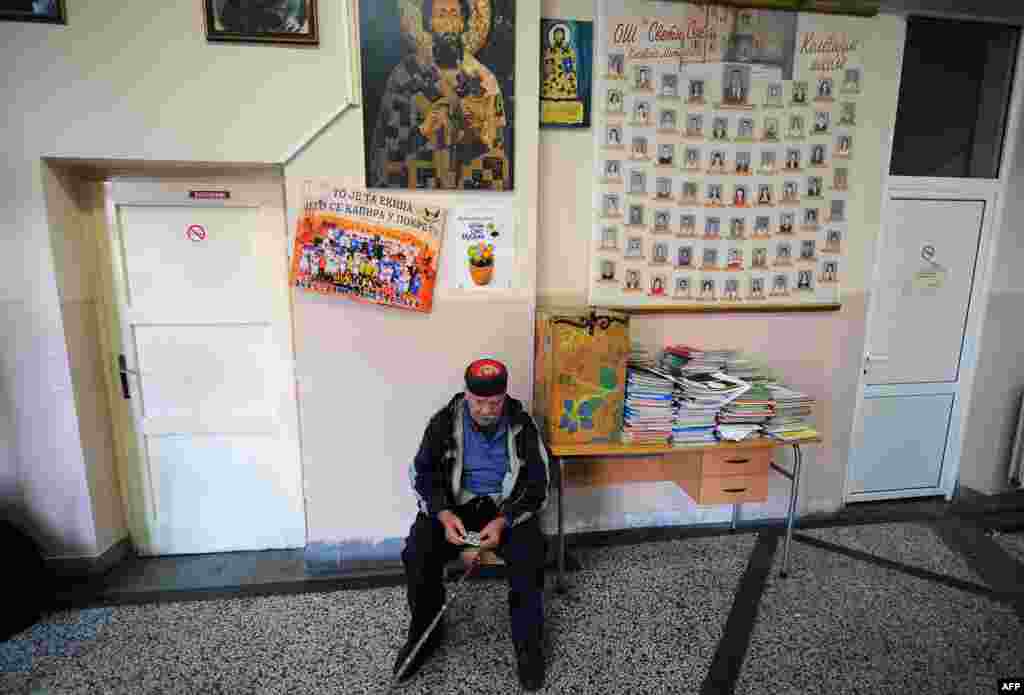 An ethnic Serb waits at a polling station in the ethnically divided city of Kosovska Mitrovica.