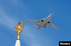 Тяжелый стратегический бомбардировщик Ту-160 пролетает во время парада Победы над Красной площадью в Москве. Россия, 9 мая 2015 года