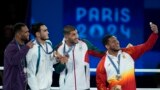 Олимпийский чемпион Лазизбек Муллажонов (второй слева) и другие призеры Игр в Париже на пьедестале