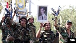 Vojnici na kamionu sa podignutim oružijem i slikama predsjednika Bashar al-Assad, u istočnom gradu Deir Zor, 16. kolovoz 2011.