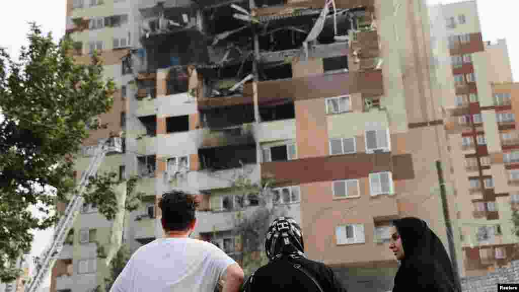 Ljudi gledaju oštećenu zgradu nakon izraelskih napada u Teheranu 13. juna.
