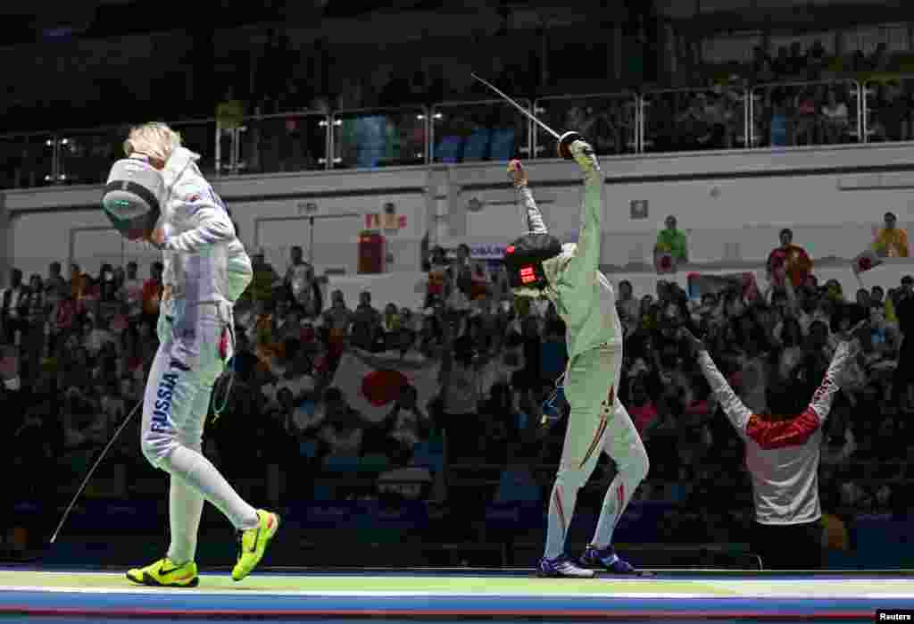 Nozomi Sato of Japan (right) celebrates winning a preliminary tie in the women's epee. 