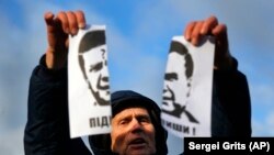 Участник Евромайдана разрывает портрет Виктора Януковича. Киев, ноябрь 2013 года