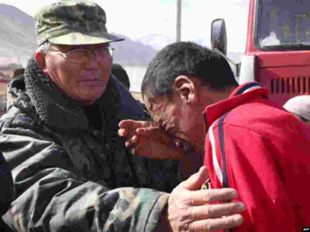 A man is comforted by rescue personnel. - Caption : A Kyrgyz man cries at the site of a major earthquake in Nura on October 6, 2008. Rescuers raced to reach a remote village in Kyrgyzstan on Monday after a strong earthquake killed at least 72 people in a mountainous area near the border with China, officials said. The quake late Sunday, which measured magnitude 6.6 according to the US Geological Survey (USGS), razed the village of Nura in the isolated Alaisky district, high in the Tian Shan mountain range.