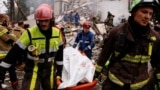 Спасатели выносят тело с места обрушения жилого дома в Киеве, Украина, 31 июля 2025 года