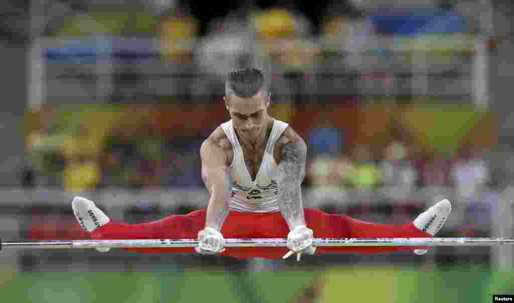 Azerbaijani gymnast Oleg Stepko competes during qualification on the horizontal bar. 