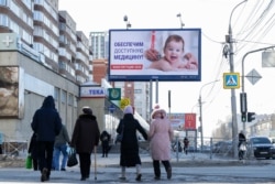 Новосибірськ: перехожі розглядають рекламний щит на підтримку голосування за внесення змін до конституції. Перенесення голосування на 22 квітня через пандемію було б головним болем для уряду Путіна