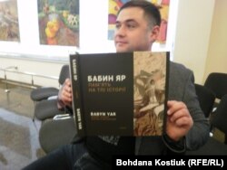 Регіональний директор організації «Українсько-єврейська зустріч» Владислав Гриневич тримає книгу