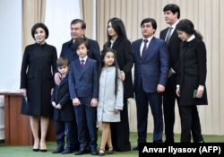 Шавкат Мирзияев (третий слева) позирует фотографам со своей семьей на избирательном участке после голосования на президентских выборах в Ташкенте, 4 декабря 2016 года.