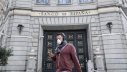 Muškarac nosi zaštitnu masku za lice dok prolazi pored Centralne banke Španije (Banco de Espana), u Barceloni, Španija, 14. marta 2020. godine.