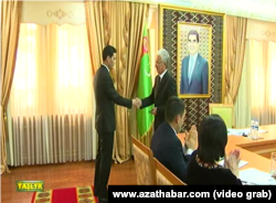Serdar Berdimuhamedow Ahal welaýatyndan mejlise deputat saýlananda, öz kakasynyň portretiniň alnynda gutlagy kabul edýär.