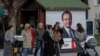 Pešaci u Prištini prolaze pored predizbornog plakata za predstojeće parlamentarne izbore na kojem je portret Aljbina Kurtija, kosovskog premijera i lidera stranke Samoopredeljenje, Kosovo, 4. februara 2025.