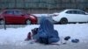 Afganistanka koja drži dijete prosi u Kabulu, Afganistan, 27. januara 2022. 