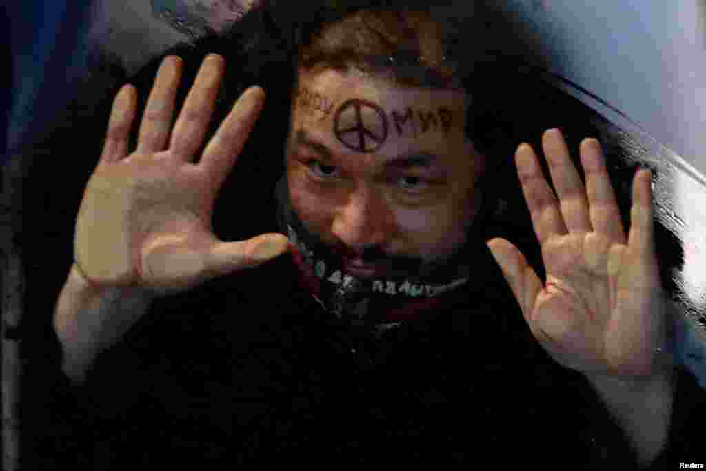 Uhapšeni demonstrant sa sloganom "Mir svijetu" na čelu u autobusu tokom antiratnog protesta, nakon što je ruski predsjednik Vladimir Putin odobrio vojnu operaciju u Ukrajini, u Sankt Peterburgu, Rusija, 24. februara 2022. 