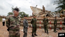 Воени аташеа и дипломати од 13 земји, вклучувајќи ги Франција и Австралија, го набљудуваат спроведувањето на договорот за прекин на огнот меѓу Камбоџа и Тајланд до уништената зграда на граничниот премин Ан Сес во камбоџанската покраина Преах Вихер на 30 јули 2025 година.