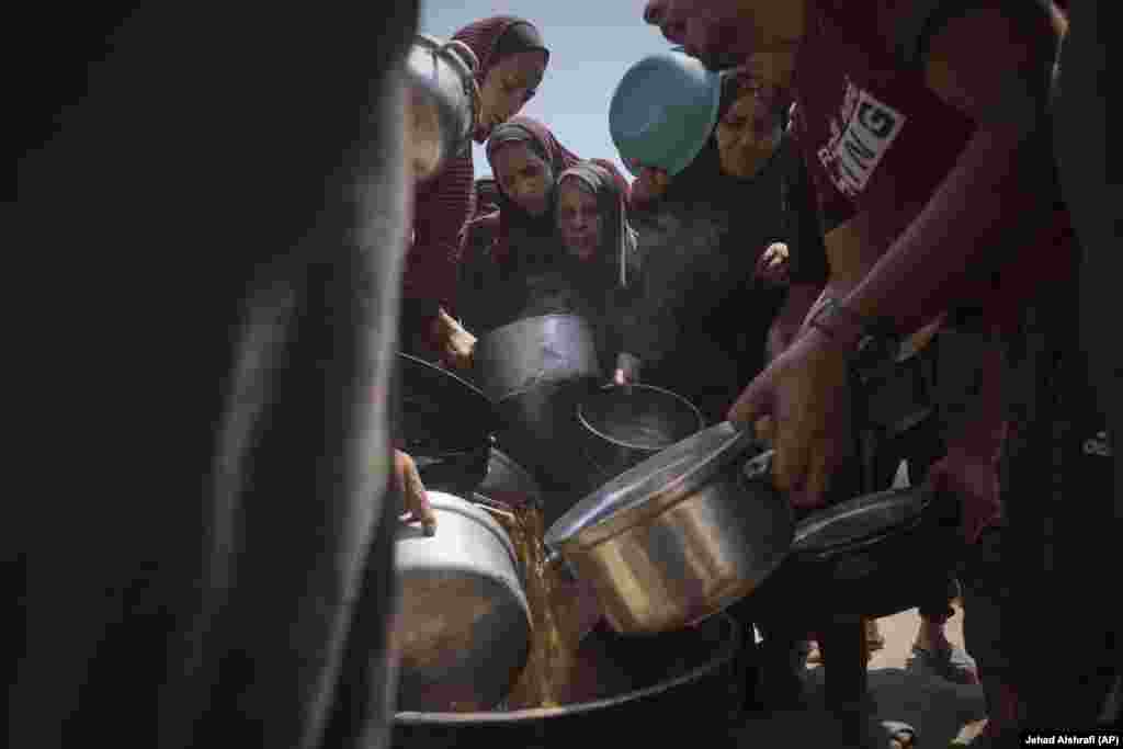 Palestinezë të zhvendosur duke marrë ushqim nga një kuzhinë popullore në Qytetin e Gazës, më 22 korrik.