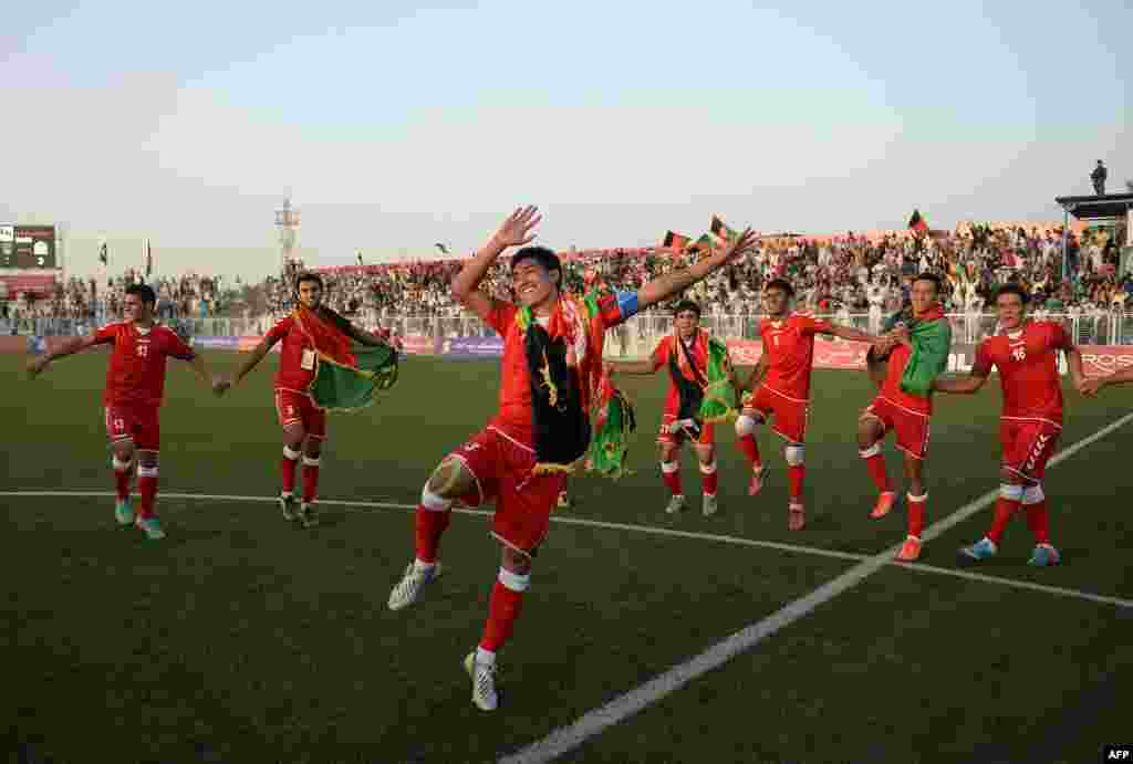 Afghan footballers celebrate their 3-0 win in a friendly against Pakistan at the Afghanistan Football Federation (AFF) stadium in Kabul. Afghanistan was hosting its first international soccer match in a decade. Organizers are hoping the FIFA-sanctioned match will ease cross-border tensions between the two neighbors. It's the first meeting in 36 years for the two nations' national soccer teams.