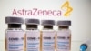 Vials with a sticker reading, "COVID-19 / Coronavirus vaccine / Injection only" and a medical syringe are seen in front of a displayed AstraZeneca logo, October 31, 2020.