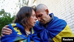 Ukrainian prisoner of war Oleksandr embraces his wife Olena after being returned to Ukraine in a prisoner swap, May 23, 2025.