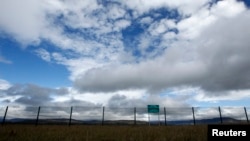 Georgia --- A warning sign is pictured behind a newly constructed fence along Georgia's de-facto border with its breakaway region of South Ossetia in the village of Dvani, October 4, 2013