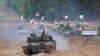 Военни машини и танкове на Полша, Италия, Канада и САЩ по време на военните учения на НАТО "Namejs 2021" на полигона в Кадага, Латвия през 2021 г.